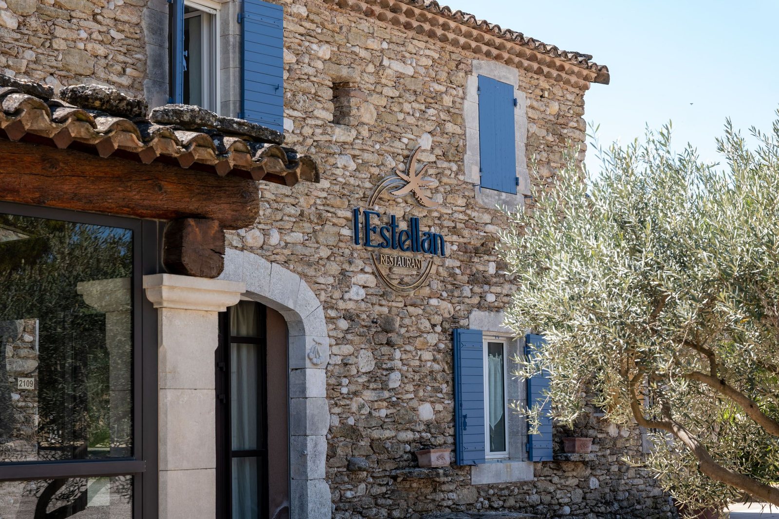 L’Estellan’s stone mas and blue shutters among olive trees.