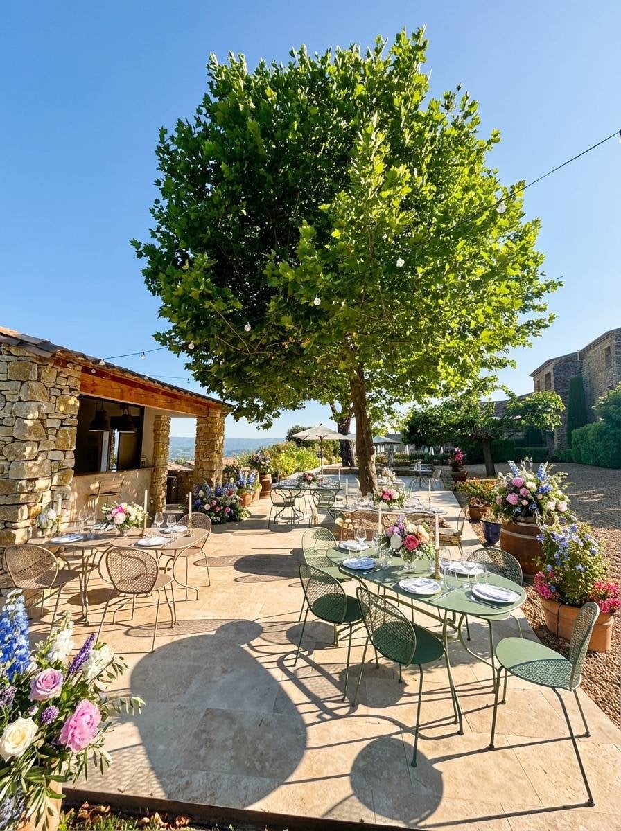 La Guinguette’s stone terrace beneath a broad shade tree.
