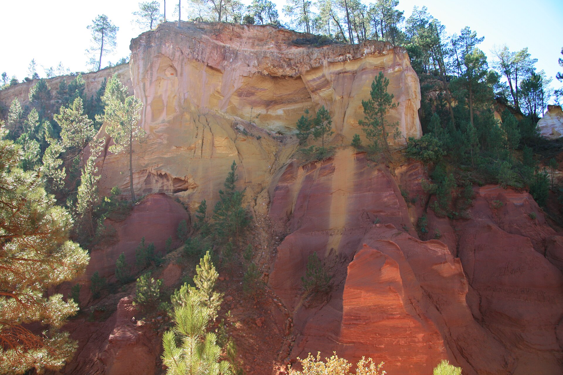 Layered yellow, red and violet cliffs among pine trees on the ochre trail