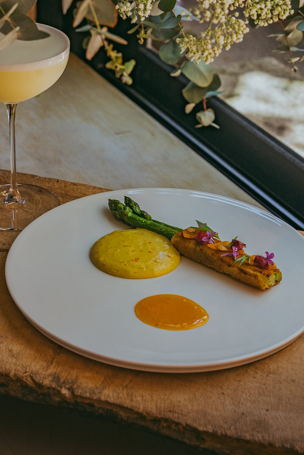 A plated vegetable dish and cocktail at Restaurant Omma