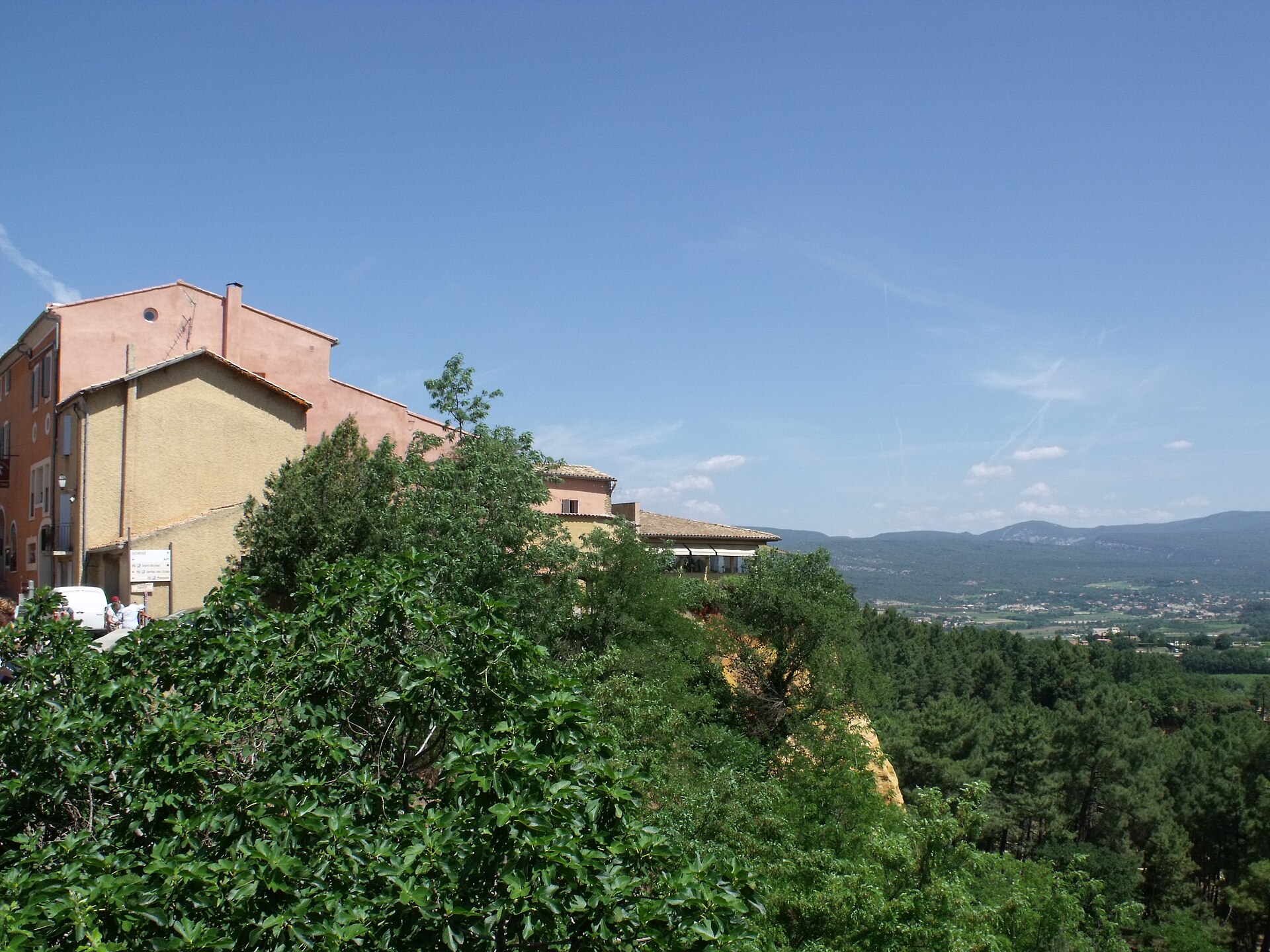 Warm village buildings overlooking the green Luberon landscape