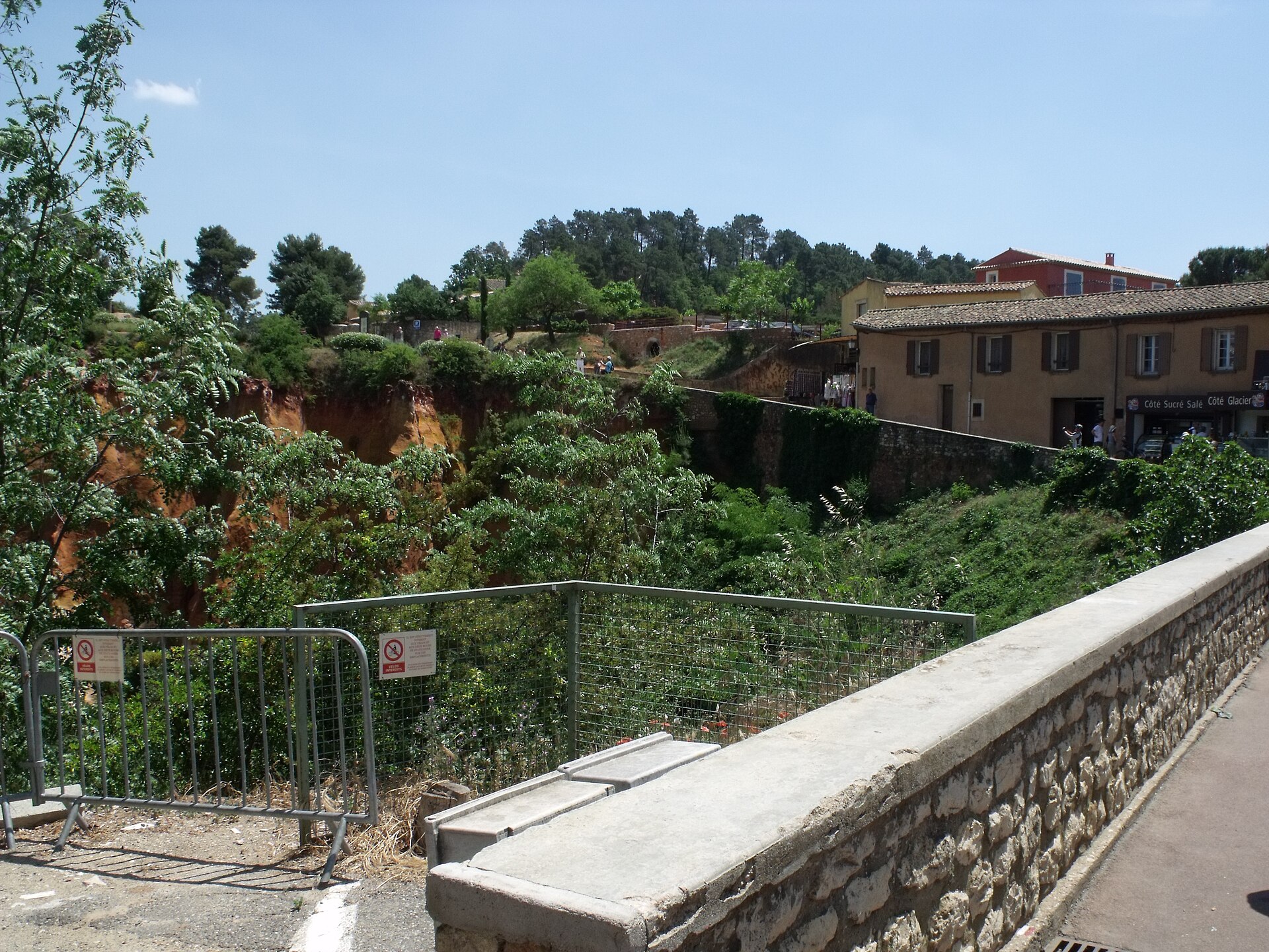 A small bridge and buildings where Roussillon meets the ochre ravine